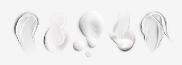 A horizontal compilation of five distinct skincare product forms against a grey backdrop. It displays, from left to right, a clear gel texture, a smooth milky white liquid, a porous foam lather with bubbles, a smooth white cream swatch, and a viscous, textured clear-to-translucent gel.