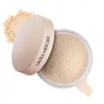 Laura Mercier Translucent Loose Setting Powder i en rund boks med lokk og løst pudder utstilt mot en ren hvit bakgrunn.